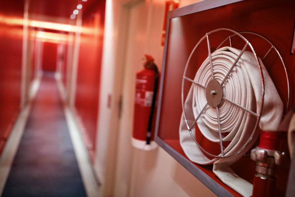 Fire extinguisher and hose reel in hotel corridor ISO 45001