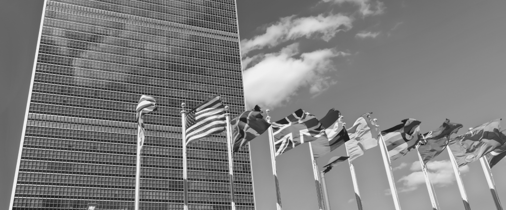 Global Offices New Header A group of flags in front of a skyscraper