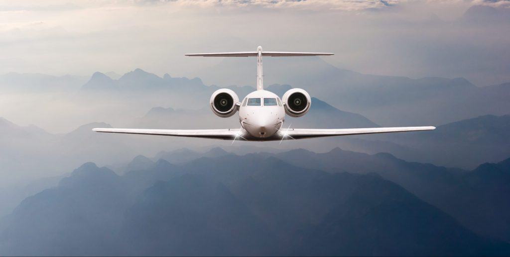 Airplane fly over clouds and Alps mountain on sunset. Front AS 9100 Certification
