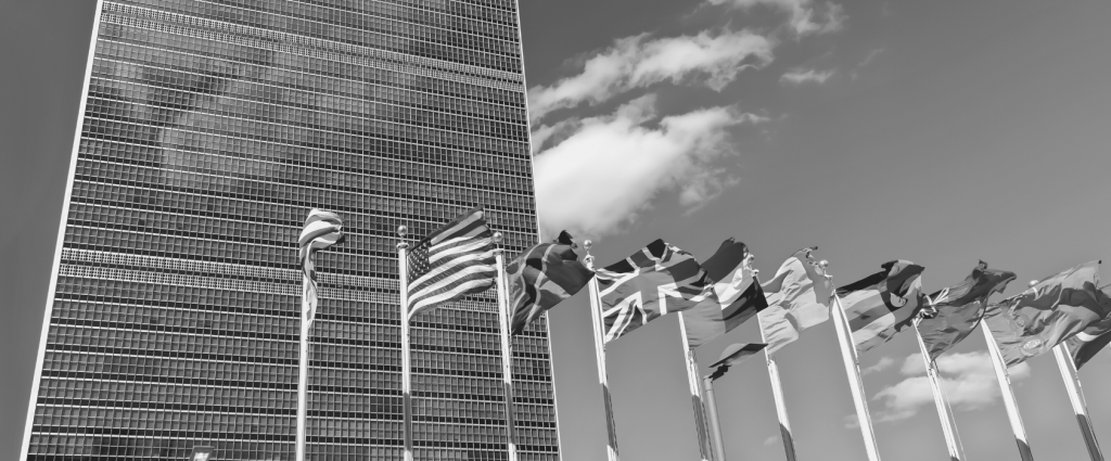 A group of flags in front of a skyscraper