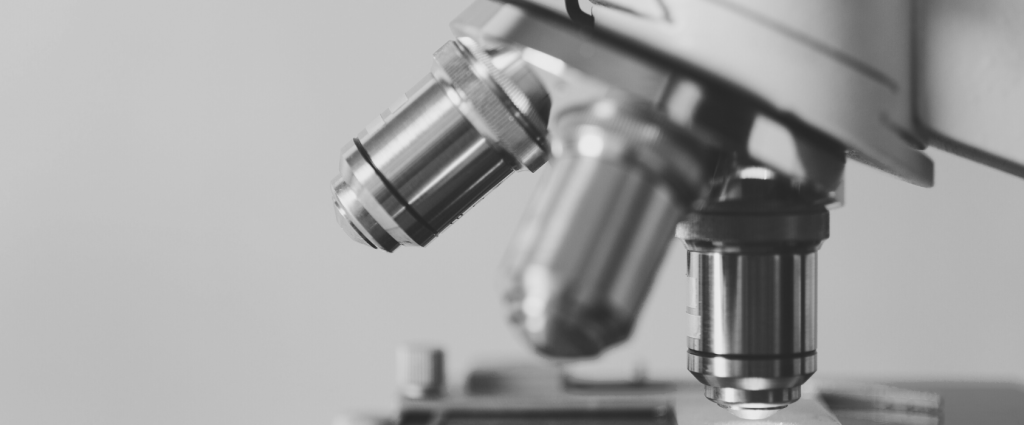 ISO 17025 Header B&W Close-up of a microscope