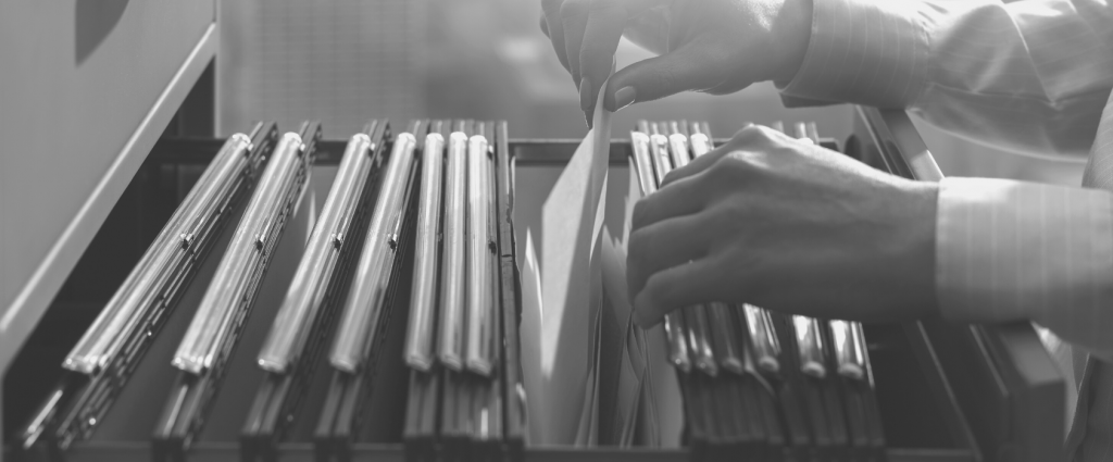 Close-up of a person's hands opening a file cabinet