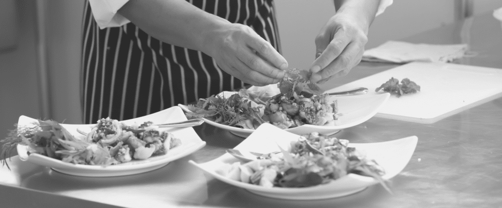 A person preparing food on plates