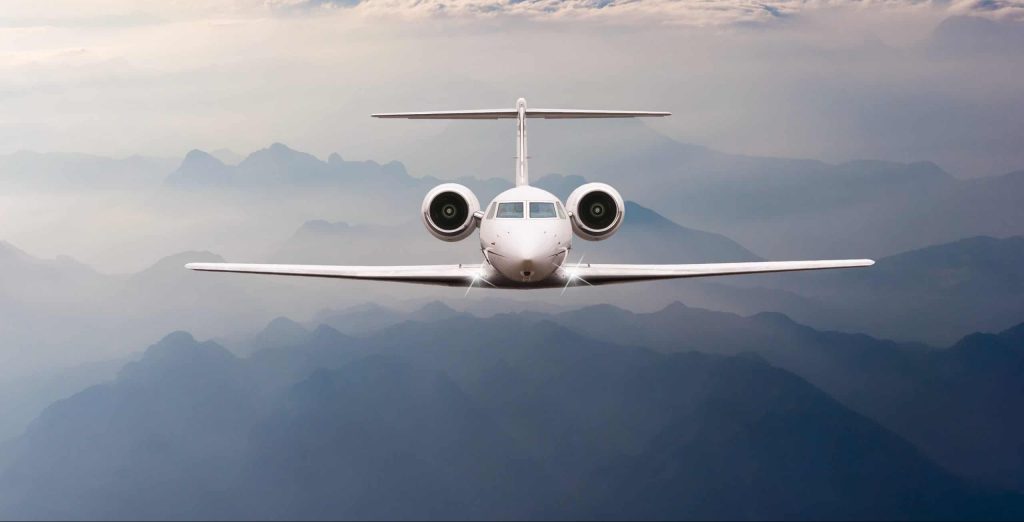 Airplane fly over clouds and Alps mountain on sunset. Front AS 9100 Certification